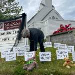 Rev. ClayOla Gitane, rector at St. Lukes Episcopal Church, places signs and bears to remember the victims of the May 24 shooting in Robb Elementary in Uvalde, Texas. More signs were being made inside and later placed to honor the victims.