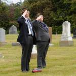 Sequim Gazette photo by Matthew Nash/ Commander Paul Renick with American Legion Post 62 and chaplain Nancy Zimmermann salute the flag during a Memorial Day service in Dungeness Cemetery.