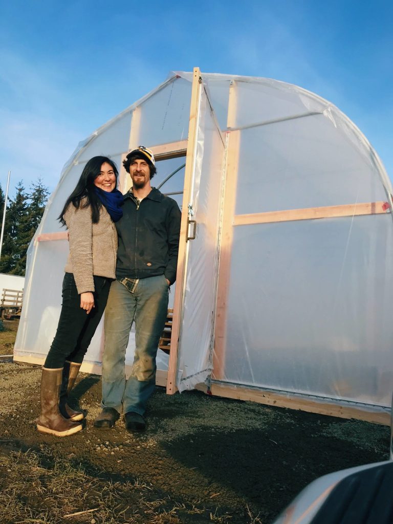 Photo courtesy of Tampopo Farm
Teresa Shiraishi and Matt Rohanna stand outside their greenhouse at Tampopo Farm.