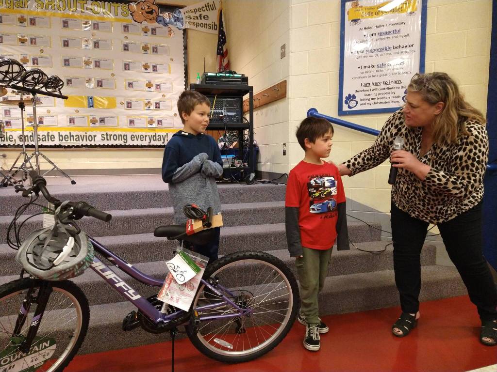 Helen Haller Elementary principal Kristi Queen present bikes to Jaxon Strait and Isaac Malkasian for their reading growth. Bikes were donated by Sequim Masonic Lodge. Submitted photo