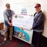 KSQM Program Director Jeff Bankston, left, accepts a $1,000 check from George Dooley, past president of the Sequim Valley Lions Club. Submitted photo