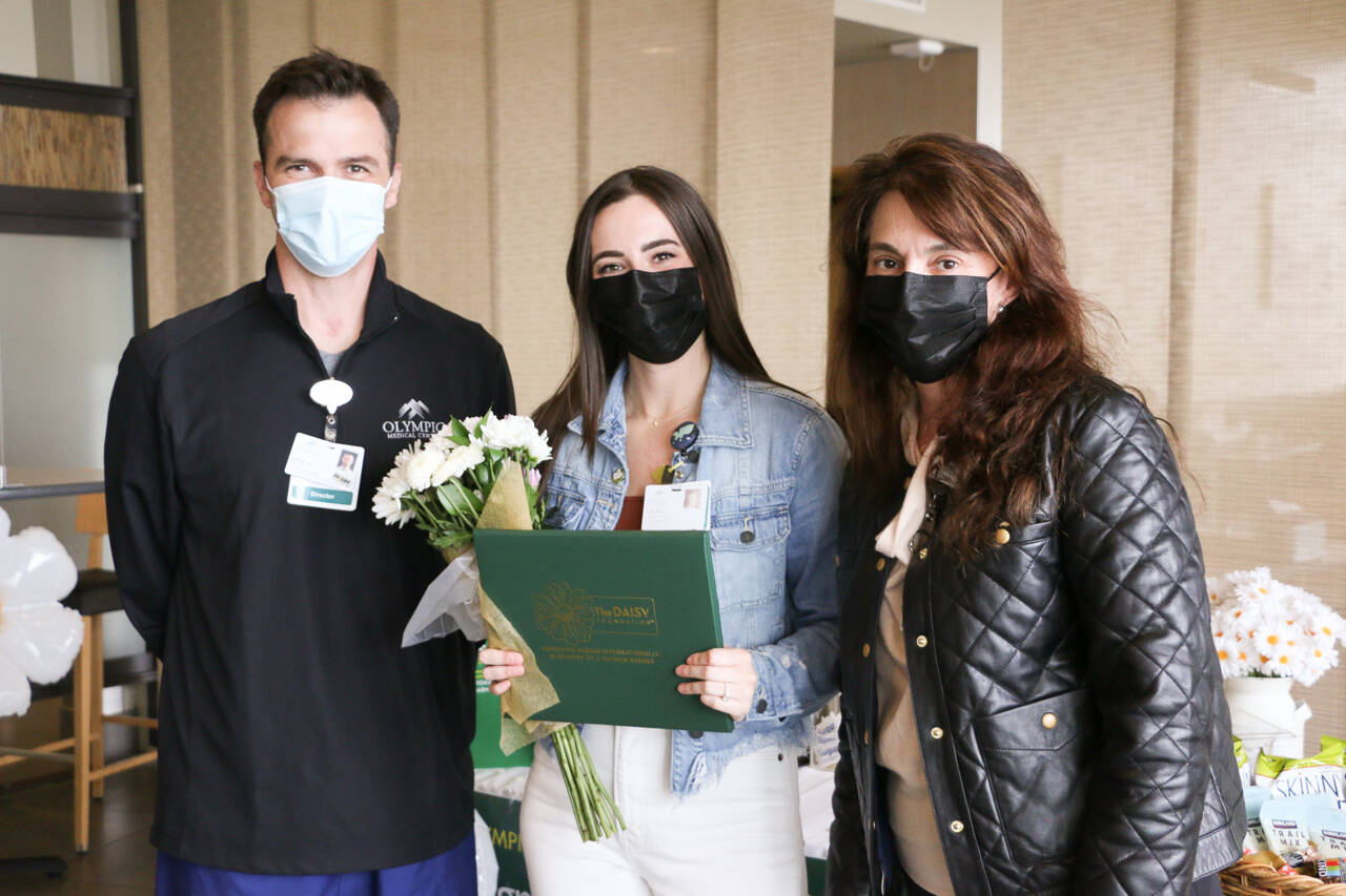 Photo courtesy of Olympic Medical Center
Aaron Possin, director of emergency services, and Chief Nursing Officer Vickie Swanson, right, present RN Elizabeth Hornsey with a DAISY Award for Extraordinary Nurses.