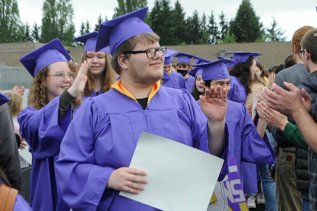 Sequim Gazette photo by Matthew Nash/ Anthony Van Der Berg waves as he and fellow Sequim High seniors take part in the 2022 Grad Walk.