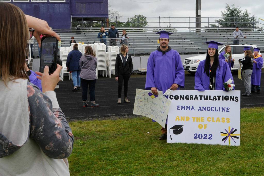 Sequim Gazette photo by Matthew Nash/ Sarah Olson takes a photo of her daughter Emma Wyant and Michael Schleve, both Sequim High seniors, right after the 2022 Grad Walk.