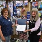 Kathy Reid, store manager at The Co-Op Farm & Garden, right, accepts a special honor from the Michael Trebert Chapter of the Daughters of the American Revolutions vice regent, Anita Reynolds. The Co-Op, at 216 E. Washington St., was selected for to receive the National Society of the Daughters of the American Revolution Flag of the United States certificate for correct usage of the U.S flag, for repeatedly demonstrating how to keep the flag flying and protect it continuously under all conditions. The local honor was awarded on Flag Day, June 14, 245 years after the day U.S. leaders approved its first national flag. President Harry Truman in 1949 signed a bill officially recognizing June 14 as Flag Day. Sequim Gazette photo by Michael Dashiell