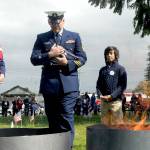 U.S. Coast Guard Chief Petty Officer Shane Thompson, accompanied by his son, Malachi Thompson, 10, a member Junior American Citizens, carries a used flag for incineration on June 14 at the Northwest Veterans Service Center in Port Angeles on Flag Day. Overseeing the burning were Ginny Sturgeon, left, and Jan Urfer, right, members of the Michael Trebert chapter of the Daughters of the American Revolution, which co-hosted the event with the Clallam County Veterans Association. Eleven used cotton flags were burned during Tuesdays Flag Retirement Ceremony. Photo by Keith Thorpe/Olympic Peninsula News Group