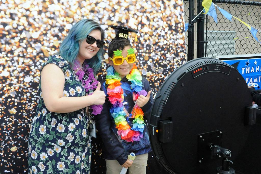 Sequim Gazette photo by Matthew Nash/ Fifth grade teacher Kaitlyn Freed and her student Jair Gomez pose for a photo at the selfie booth at the drive-through celebration for students moving on to middle school from Helen Haller Elementary.