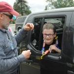Sequim Gazette photo by Matthew Nash/ Fifth grade teacher Eric Danielson greets his student Max Brouillard on June 17 and gives him a certificate and candy lei for completing the year and moving on to middle school.