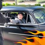 Sequim Gazette photo by Matthew Nash/ Eighth grader Rylee Gillaspy high fives Sequim Middle Schools Timberwolf during the schools drive-through celebration of students moving onto high school. Rylee rode in his dad Lucas 1949 Chevy Fleeting that he helped him work on.