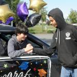 Sequim Gazette photo by Matthew Nash/ Zach Post high fives Clyde Baldassare as he goes through the Sequim Middle School drive-through event on June 16.