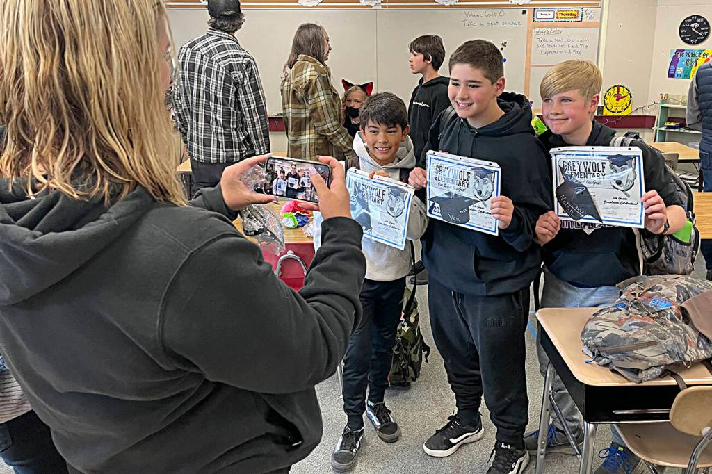 Mary Johnson snaps a photo of, from left, Coleman Keate, Van Johnson and Nolan Stewart in Josiah Sutherlands class at Greywolf Elementary after they received their certificates for finishing fifth grade and moving onto middle school.