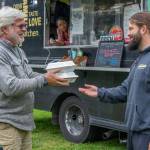 Jay Pederson, a full-time RV traveler, receives dinner for himself and his wife from Caleb Messinger at the Southern Nibble food truck, parked at the John Wayne Marina Resort on the outskirts of Sequim. Sequim Gazette photo by Emily MatthiessenSequim Gazette photo by Emily Matthiessen
