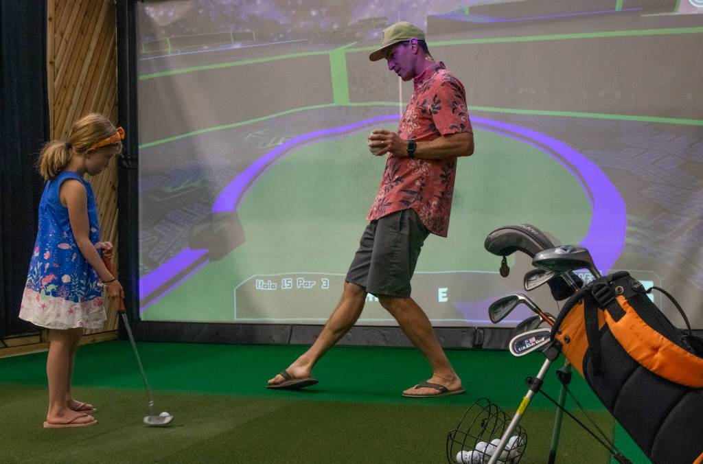 Sequim Gazette photo by Emily Matthiessen
Mae Shantz receives some instruction from her father, Adam Shantz, as she plays indoor miniature golf at Blade Bros Golf Club at the Rock Plaza, 10171 Old Olympic Highway in Sequim. Adam is one of five friends who enjoy playing golf together and created Blade Bros to provide 24 hour a day access to golf practice for the local community.