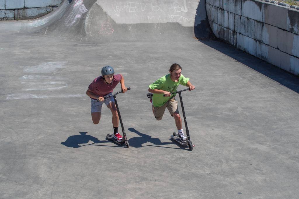 Preston Kurtz and Gunnar Peterson compete in a scooter race during the fundraiser for Carrie Blake Skatepark on Saturday. Sequim Gazette photo by Emily Matthiessen