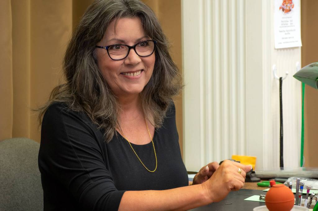 Sequim Gazette photo by Emily Matthiessen / New co-owner of Coles Jewelry, Debbie Hunt, smiles at her daughter from her her work desk. Hunt worked at Coles Jewelry for 17 years before the previous owners retired last year.
