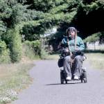 Photo by Keith Thorpe/Olympic Peninsula News Group
Ian Mackay rides his motorized wheelchair on a section of the Olympic Discovery Trail at Robin Hill County Park west of Sequim on July 1.