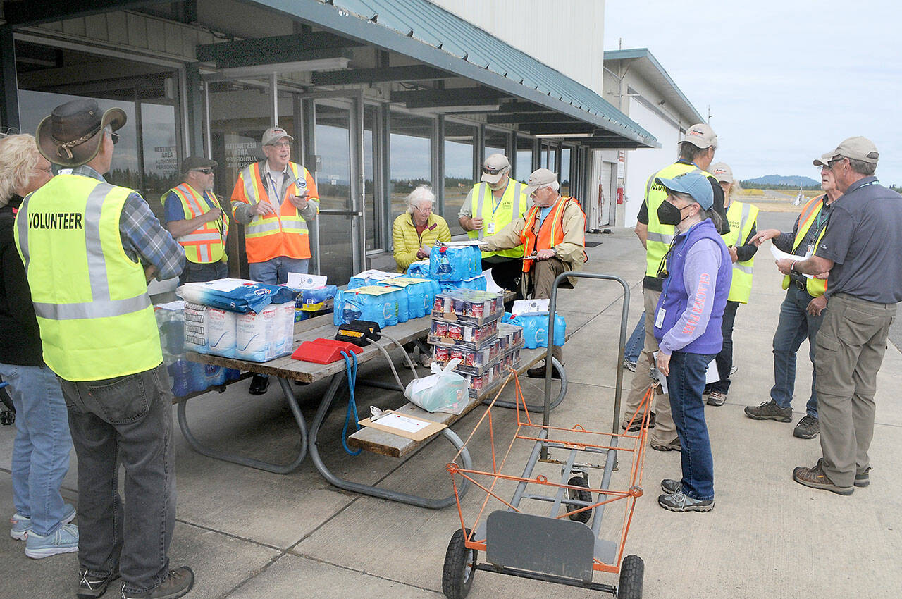 Photo by Keith Thorpe/Olympic Peninsula News Group / Clallam County Disaster Airlift Response Team members assemble food and water for a training session on July 9 at William R. Fairchild International Airport in Port Angeles that sent food supplies to five smaller airports across the county.