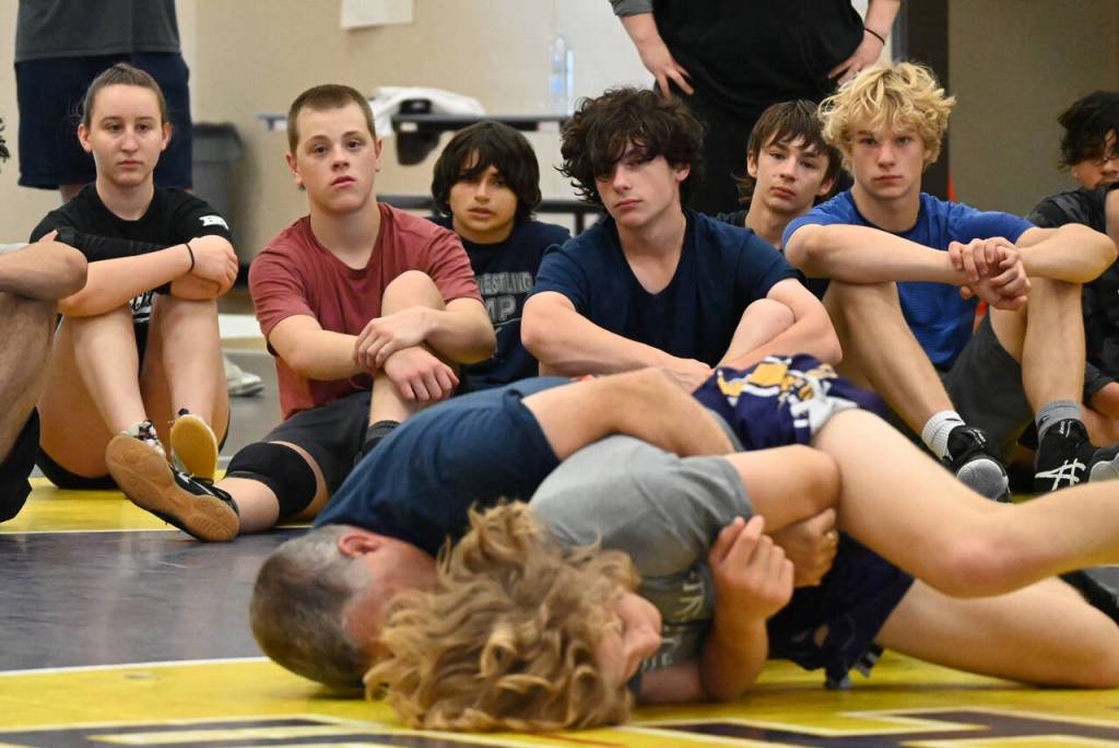 Sequim Gazette photo by Michael Dashiell / Campers look on as Gene Mills demonstrates a move with Sumners Cody Miller at a summer camp in Sequim last week.