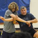 Former collegiate, national and world wrestling champion Gene Mills, right, demonstrates a move with Sumners Cody Miller at a summer camp in Sequim last week.