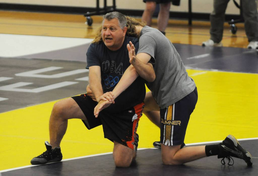 Sequim Gazette photo by Michael Dashiell
Former collegiate, national and world wrestling champion Gene Mills, left, demonstrates a move with Sumners Cody Miller at a summer camp in Sequim last week.