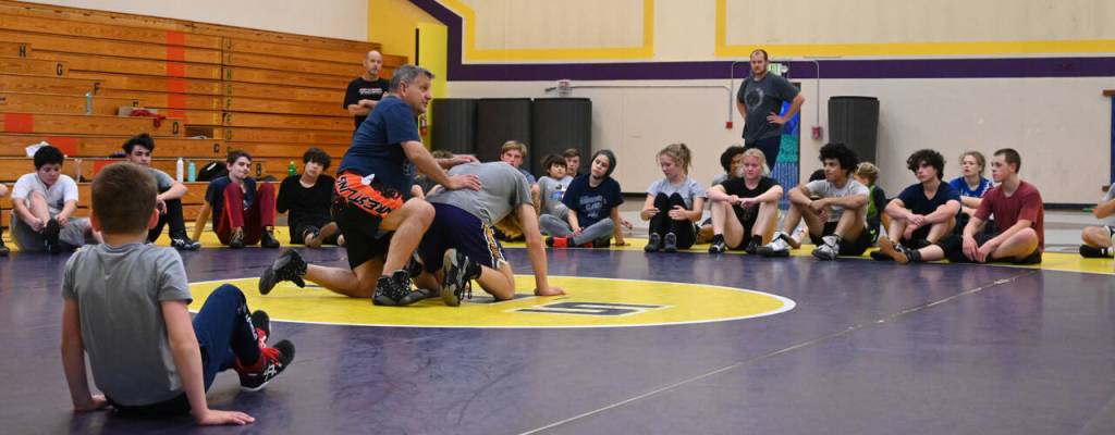 Sequim Gazette photo by Michael Dashiell / Campers listen in as Gene Mills demonstrates a move with Sumners Cody Miller at a summer camp in Sequim last week.