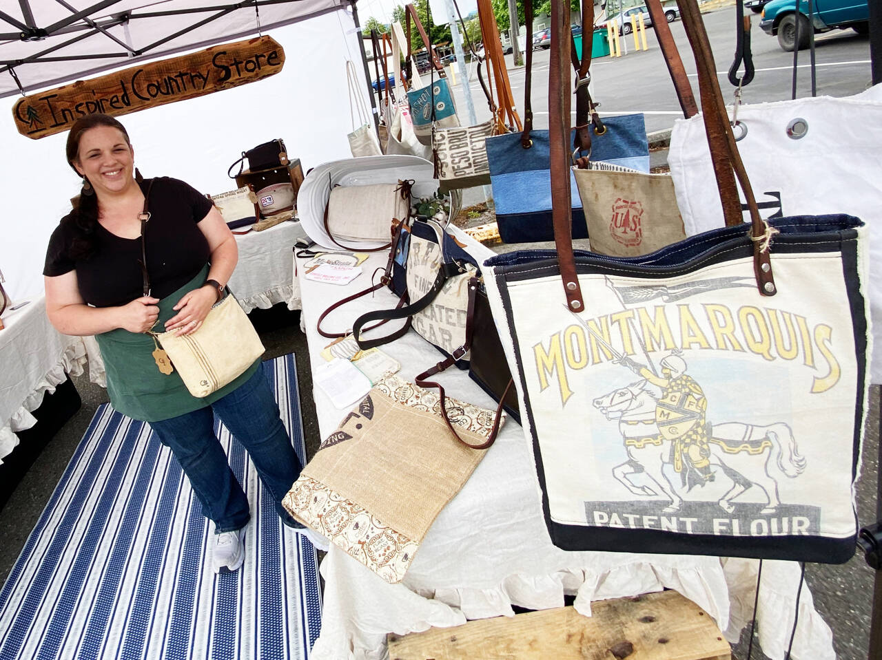 Photo by Emma Jane Garcia/Sequim Farmers & Artisans Market
Tricia Gillespie of Inspired Country Store displays assortment of purses, tote bags, zipper pouches and more at the shops Sequim Farmers & Artisans Market booth.