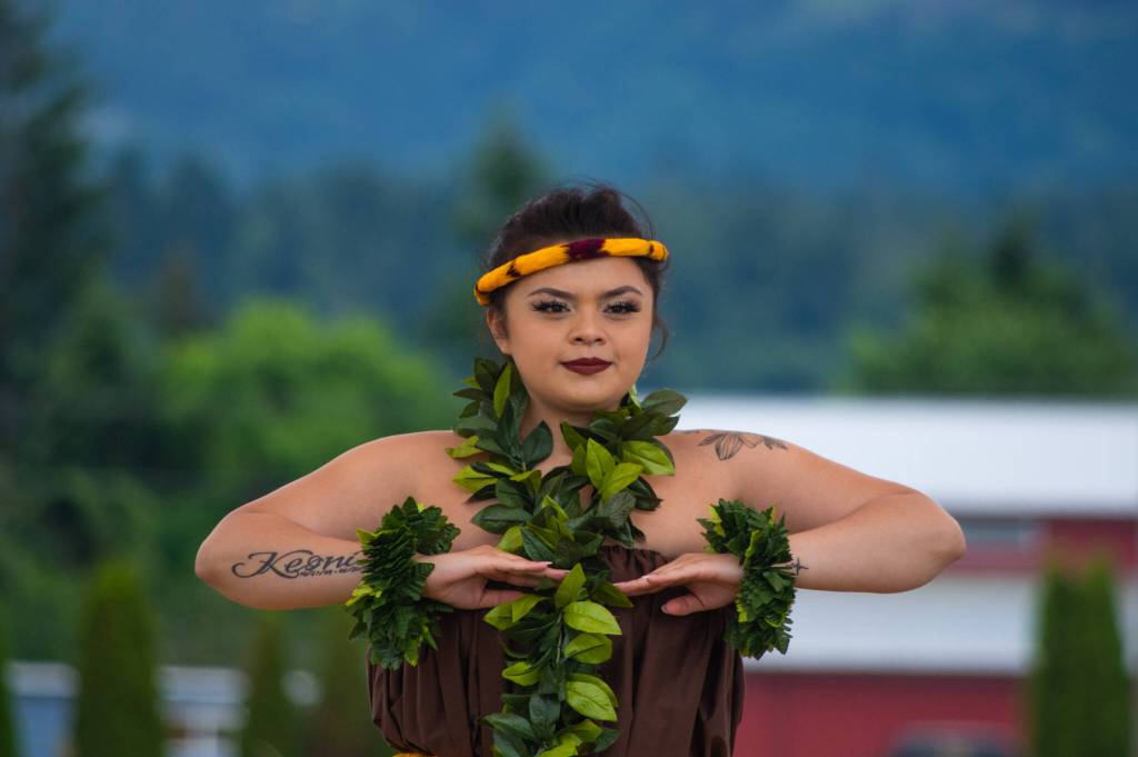 Sequim Gazette photo by Emily Matthiessen / Alakaʻi in training, Casara Desiree Hemakanamaikapu`uwai Caro demonstrates a hula for a Sequim audience on Saturday in the field behind the Sequim Library on july 16. Her mother, Candace Marie Kananiokamokihana Melendez of Hālau Hula Ka Lei Mokihana I Ka Ua Noe, said that her daughter began learning the hula in the womb. North Olympic Library System hosted the dance, history and language workshop as part of their summer reading program.