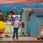 Sequim Gazette photo by Emily Matthiessen
Kumu Hula Mokihana Melendez (left) and featured dancer Alakai Makana Caro (right) of Halau Hula Ka Lei Mokihana I Ka Ua Noe invite Sequim resident Amaya Franich to try the uliuli, a type of gourd rattle with stones or seeds and feathers. Franich, participating in this NOLS summer reading event, said it was fun.