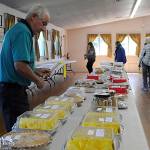 Sequim Gazette photo by Matthew Nash/ John Raske with Fairview Grange looks at some of the items hes considering to bid on for the All-Grange Dessert Auction on July 23. His wife baked five items, and Fairview 23 total, he said.