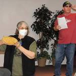 Sequim Gazette photo by Matthew Nash/ Judy Moilanen with Crescent Grange holds up a marionberry pie made for bidding as Dave McDaniels, president of Sequim Prairie Grange, looks for bidders on July 23 at the All-Grange Dessert Auction.