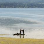 Photo by Keith Thorpe/Olympic Peninsula News Group / Juli Sias of Sequim, left, passes her grandson, Nathanael Sias, 1, to her son, Landon Sias, after the family spent time kayaking on the waters of Sequim Bay east of Sequim on July 27. The trio found the adventure a good way to beat the heat of a stretch of unseasonably warm temperatures across much of the North Olympic Peninsula.
