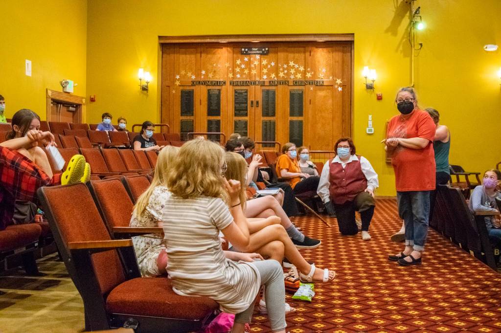 Sequim Gazette photo by Emily Matthiessen / Director Marissa Meek, standing, speaks to some of the 40-member cast of The Hobbit at a recent rehearsal she called, like a three-ring circus. Meek and cast and crew have been putting together the show featuring giant puppets, including a 30-foot dragon, 10-foot trolls and a 5-foot spider. The cast spans the generations from 6 to those older than 70.