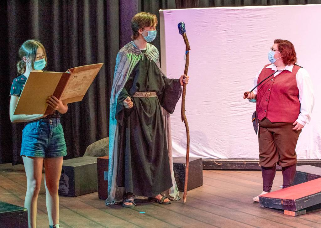 Sequim Gazette photo by Emily Matthiessen / Roxy Woods, a wizard/storyteller, along with Misha Ostrovsky as the wizard Gandalf and Taylor Dowley as the hobbit Bilbo Baggins, rehearse the Good day! scene in Olympic Theatre Arts upcoming prtoduction of The Hobbit, which has a cast and crew of more than 50 and features oversized puppets and a multitude of handmade props.