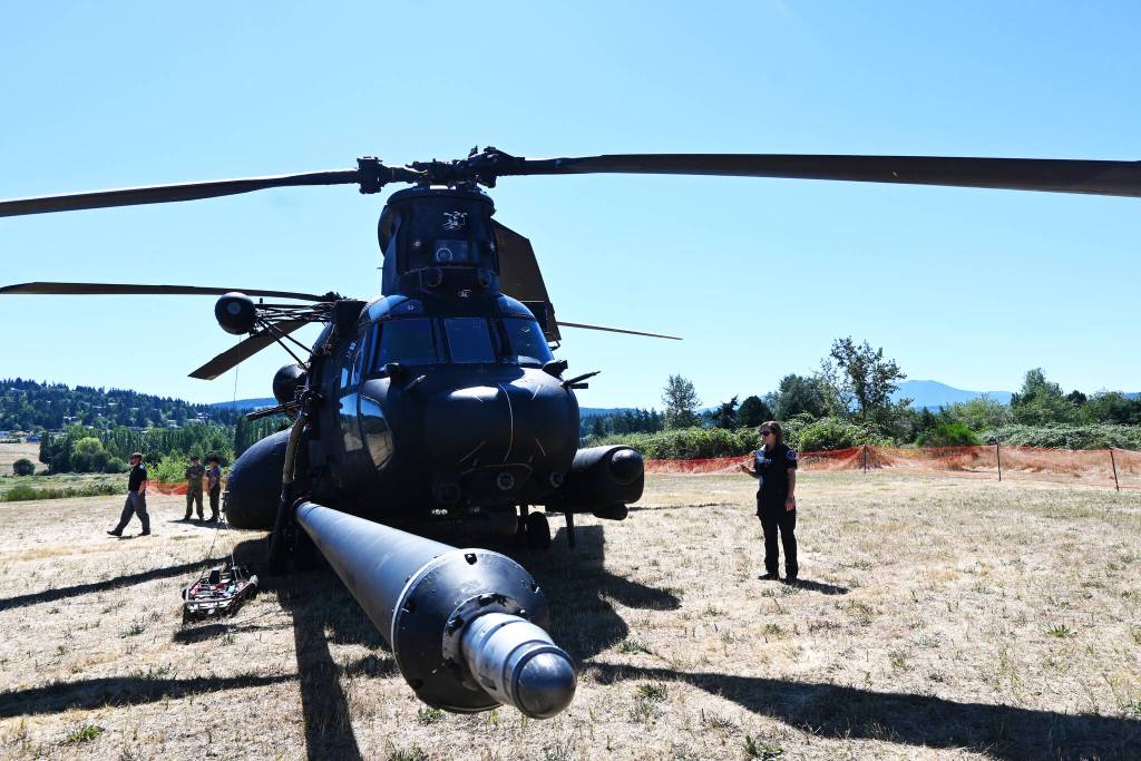 Sequim Gazette photo by Michael Dashiell / Attendees of the 2022 Unity of Effort event, held Aug. 6 at Security Services Northwest, get an inside look at a special forces Chinook helicopter.