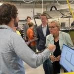 Sequim Gazette photo by Matthew Nash/ Rob Cavagnaro with PNNL-Sequim shows Jennifer Granholm, U.S. Secretary of Energy, U.S. representative Derek Kilmer, and others a wearband sliding bearing thats rusted as part of a prototype wave energy converter biofouling test. Researchers looks to reduce maintenance costs for companies in the ocean by testing how residue accumulates and best methods for keeping it off.