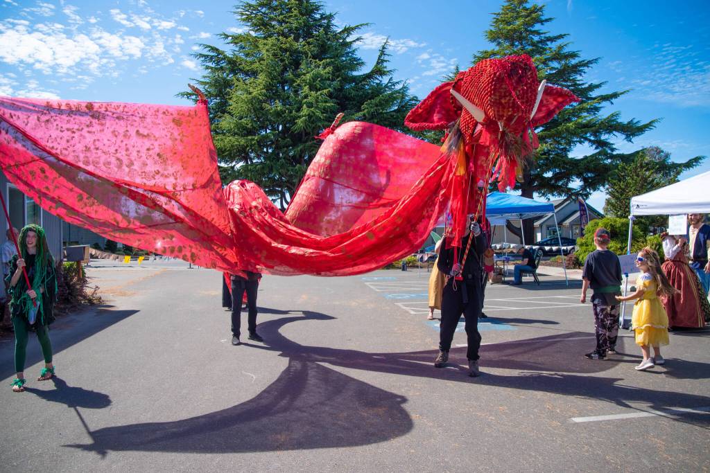 Sequim Gazette photo by Emily Matthiessen / During Olympic Theatre Arts Renaissance Faire last weekend, members of The Hobbit production parade their dragon puppet Smaug through OTAs parking lot.