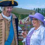 Jeff Dacus as George Washington shares a pleasant conversation with Randa Wintermute of Sequim at the NW Colonial Festival on Friday. Dacus said this was his first time playing George Washington. He said that Washington was mostly schooled at home and was an autodidactic. He understood upper math to become a surveyor at 16 years of age. He said that Washington was heavily influenced by The 101 Rules of Civility.