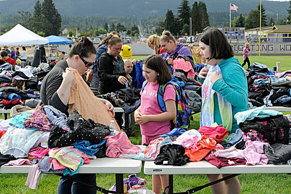 Sequim Gazette photo by Matthew Nash
Jen Williams looks at clothes with Linnea, 8, and Sophia, 11, Mager at the Back to School Fair. The sisters will be going into third and sixth grades, they said. See story and more photos of the event on page A3.