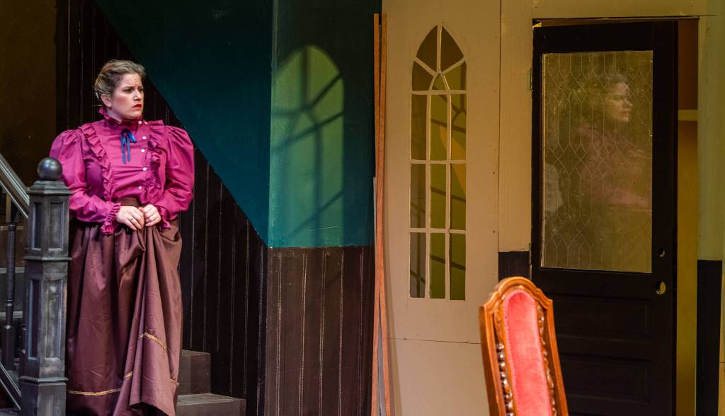 Sequim Gazette photo by Emily Matthiessen / Tara Dupont plays homicidal Martha Brewster in Arsenic and Old Lace, OTAs upcoming production directed by Steve Humphrey. Shadow and light are used to great effect on the set. Dupont said, I like the way the aunties are thinking theyre doing these men a service.