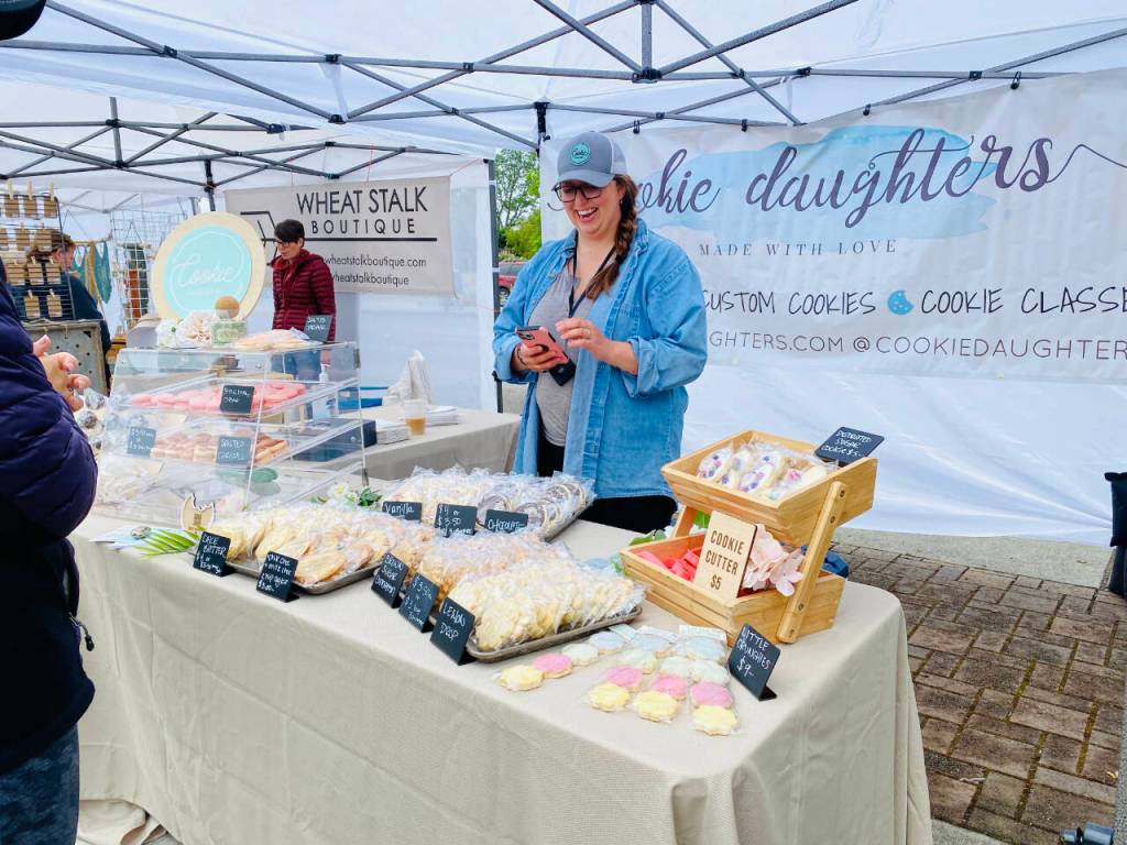 Photo by Emma Jane Garcia/Sequim Farmers & Artisans Market / Sarah Harrington greets customers at the Cookie Daughters booth at the Sequim Farmers & Artisans Market.