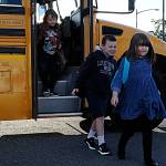 Sequim Gazette photos by Matthew Nash
Greywolf Elementary students, from left, Judah Freeman, Stephen Vincent Preston, and Genesis Freeman transfer buses from the Sequim School District Athletic Field parking lot on their way to start the school year on Sept. 7.