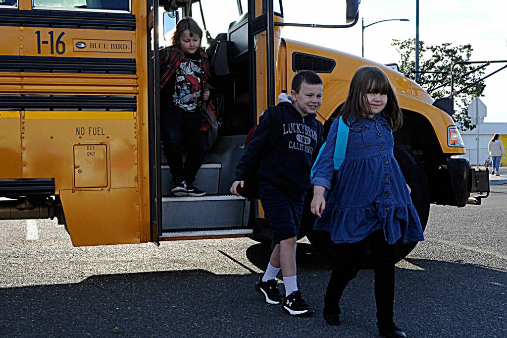 Sequim Gazette photos by Matthew Nash
Greywolf Elementary students, from left, Judah Freeman, Stephen Vincent Preston, and Genesis Freeman transfer buses from the Sequim School District Athletic Field parking lot on their way to start the school year on Sept. 7.