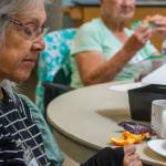 Cecelia Schouten eats an orange at Tims Place a weekly gathering of volunteers and people who live with memory loss hosted by Trinity United Methodist Church in Sequim. Cecilia and her daughter said that she grew up in Azusa, Calif., surround by orange groves. Her first job was packing oranges, and she says she loves the smell of orange blossoms and still loves to eat oranges.