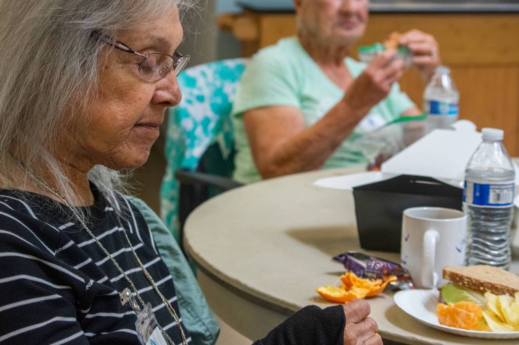 Cecelia Schouten eats an orange at Tims Place a weekly gathering of volunteers and people who live with memory loss hosted by Trinity United Methodist Church in Sequim. Cecilia and her daughter said that she grew up in Azusa, Calif., surround by orange groves. Her first job was packing oranges, and she says she loves the smell of orange blossoms and still loves to eat oranges.