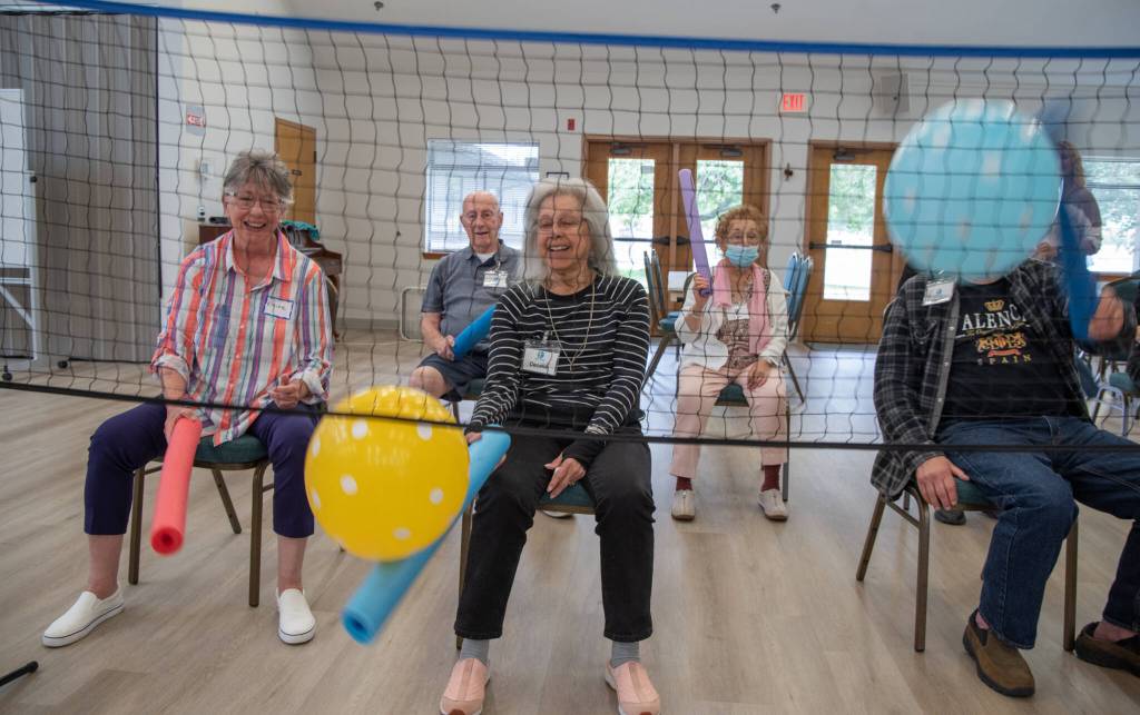 Sequim Gazette photoS by Emily Matthiessen
Elaine Bradford and Cecelia Schouten participate in a variation of balloon volleyball in which participants keep three balloons going by hitting them with pool noodles. This game is a favorite at Tims Place and other Respite for All gatherings. Schouten, according to her daughter Valerie Schouten, was always very athletic and loved climbing trees as a child. She was recruited to join the All-American Girls Professional Baseball League, but her father said, no.