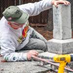 Sequim Gazette file photo by Emily Matthiessen/ Marion Mick Hersey checks the placement of the headstone of the 15-year-old son of E.C. and M.E. Payne in 2021. Hersey is a National Historical Preservationist and Navy veteran from Kitsap County, who came to Sequim to help members of the Sequim Prairie Garden Club and other volunteers repair headstones in the Pioneer Memorial Park.