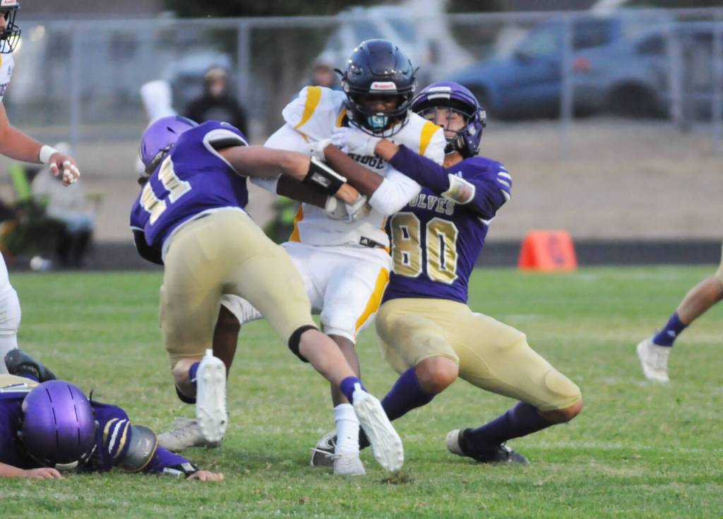 Sequim Gazette photo by Michael Dashiell / Aiden Gockerell and Isaiah Moore tackle Bainbridge receiver Micah Bryant in the first quarter of an Olympic League match-up on Sept. 16.