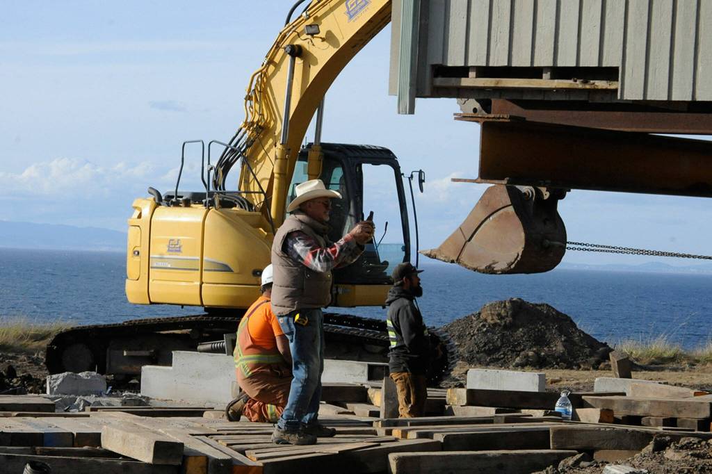 Sequim Gazette photo by Matthew Nash/ Homeowner Jim Nichols takes a video of crews moving his home away from a Dungeness hillside on Sept. 16. Over 30 years, the home went from about 100 feet away from the hillside to about 30 feet.