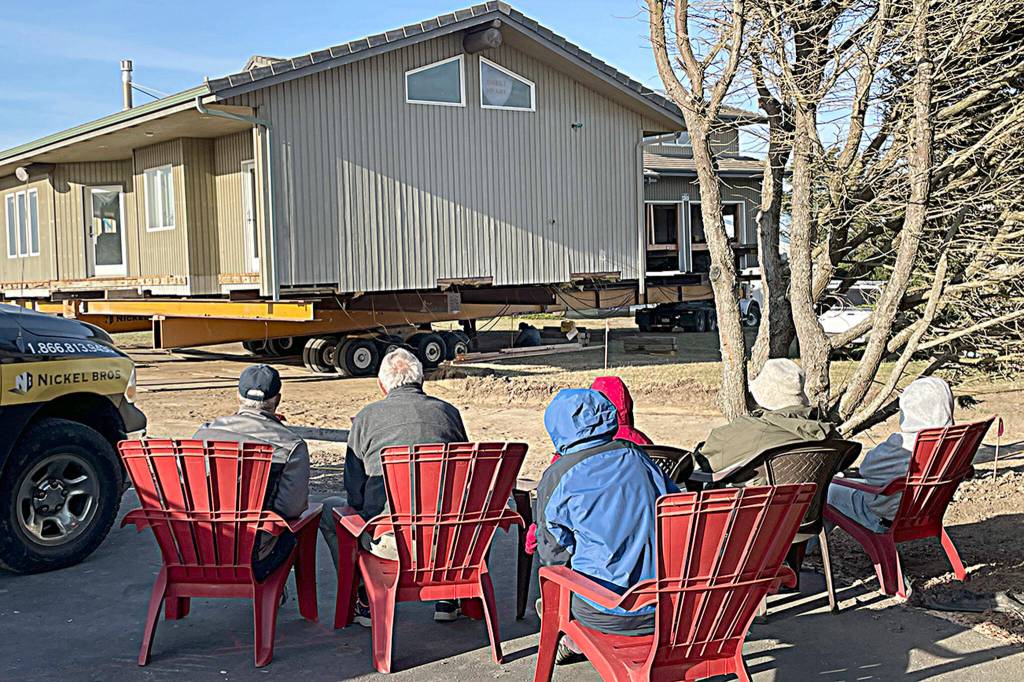 Sequim Gazette photo by Matthew Nash/ Neighbors sat and watch a Dungeness home move about 100 feet away from the bluff on Sept. 16.