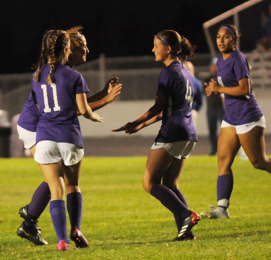 Sequim High teammates congratulate freshman forward Raimey Brewer after she assisted Taryn Johnsons fifth score of the evening of the Wolves 6-1 win over Olympic on Sept. 20.